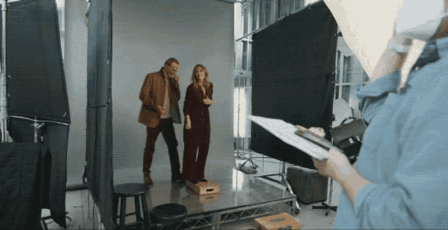 a man and woman are posing for a photo in a studio