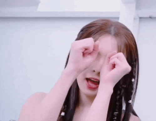 a young woman is making a funny face with her hands in the air .