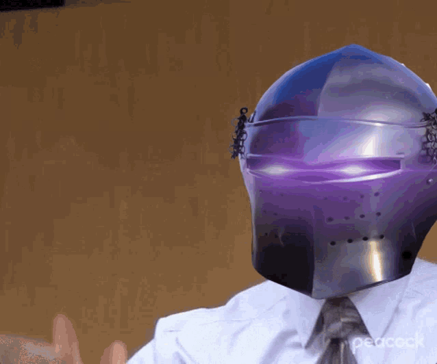 a man wearing a purple helmet with peacock written on it