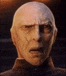 a close up of a bald man 's face with a very serious look on his face .