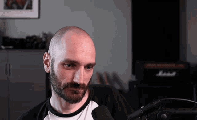 a man sitting in front of a marshall amplifier