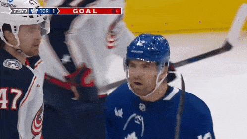 a hockey player with the number 12 on his jersey stands on the ice