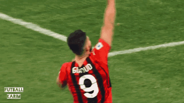 a soccer player wearing a fly emirates jersey celebrates his goal