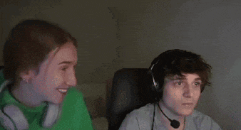a man and a woman wearing headphones are sitting in front of a computer .