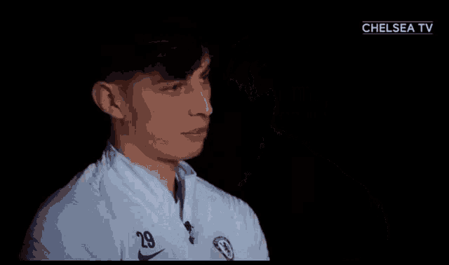 a man in a white shirt with a chelsea logo on it