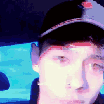 a man wearing a baseball cap is sitting in a car with a blurry picture of his face