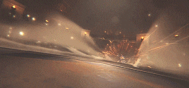 a blurred image of a city at night with a bridge in the background