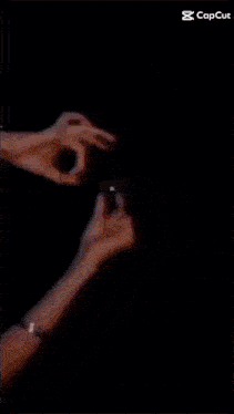 a person is holding a sparkler in front of a black background that says cap cut