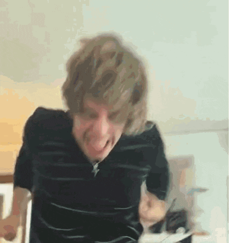 a man in a black shirt is making a funny face with his mouth open