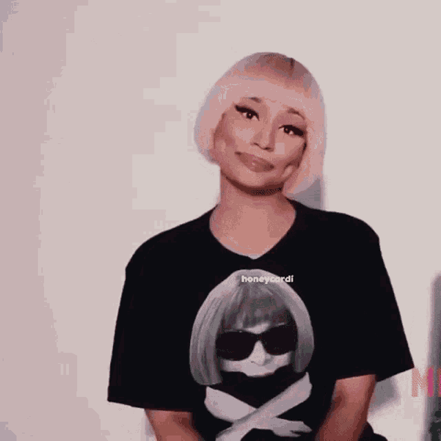 a woman wearing a black t-shirt with a picture of a woman on it is making a funny face .