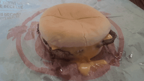 a wendy 's cheeseburger is sitting on a piece of plastic