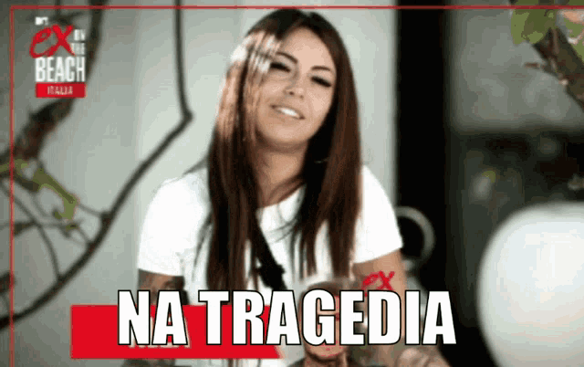 a woman is smiling in front of a sign that says na tragedia on it