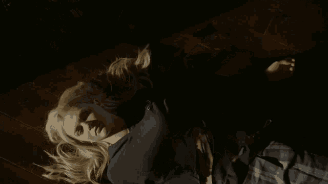 a woman in a plaid skirt is laying on the ground