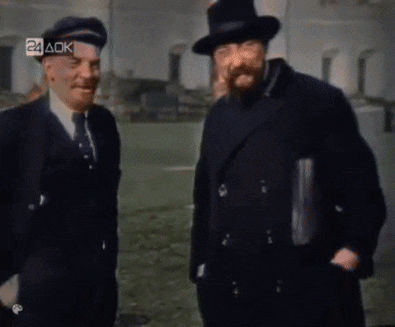 two men are standing next to each other in front of a building with the letters 24 ack on the bottom