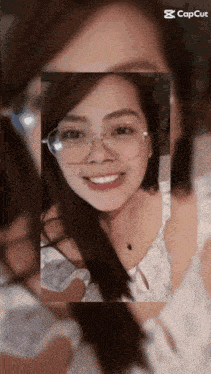 a woman wearing glasses is smiling in a capcut app