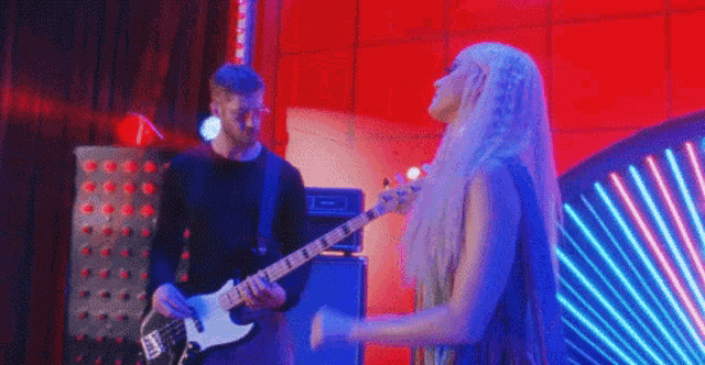 a man is playing a guitar and a woman is singing .