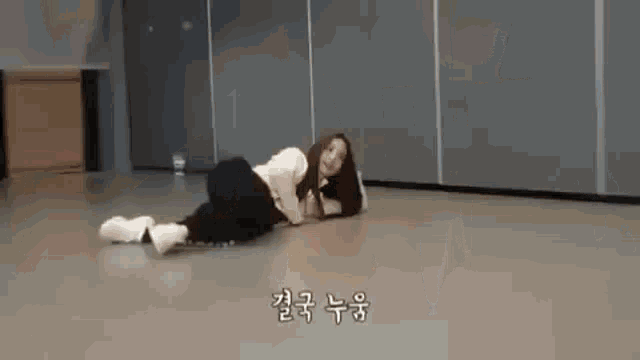 a woman is laying on her stomach on the floor in a gym .