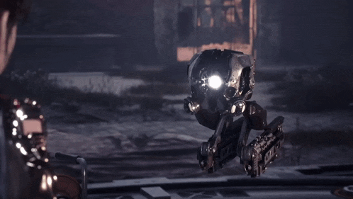 a person standing next to a robot that is flying in the air