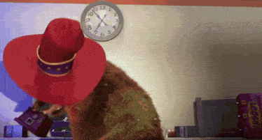 a cartoon character in a red hat is standing in front of a clock that shows the time as 10:10