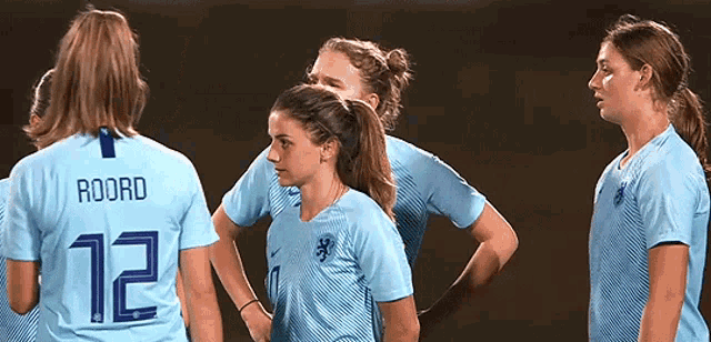 a group of female soccer players one of whom is wearing the number 12 jersey