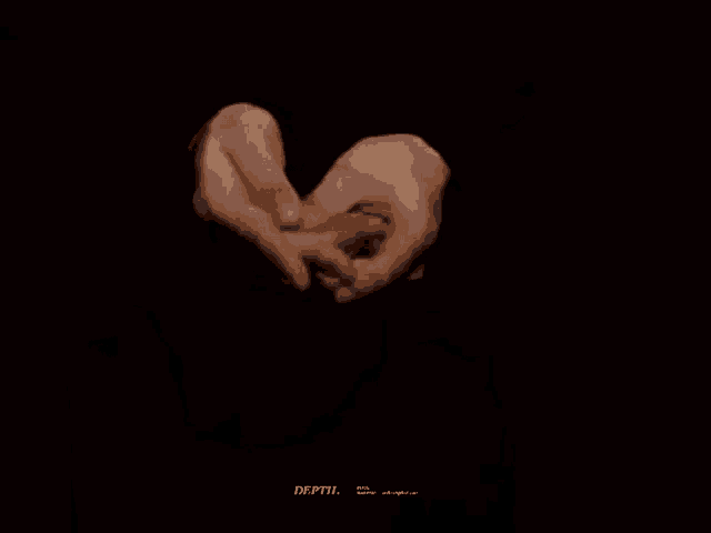 a person is holding their hands together in the shape of a heart in the dark .