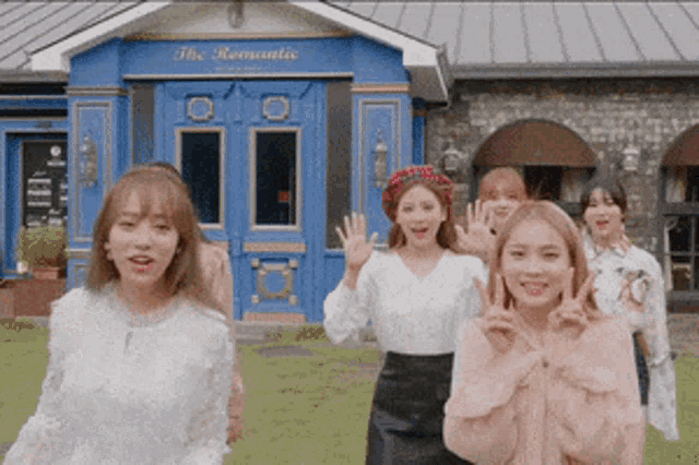 a group of young women are standing in front of a building that says the romantic
