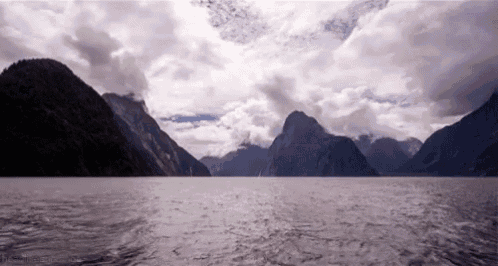 a body of water with mountains in the background