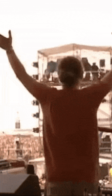 a man with his arms outstretched is standing in front of a crowd