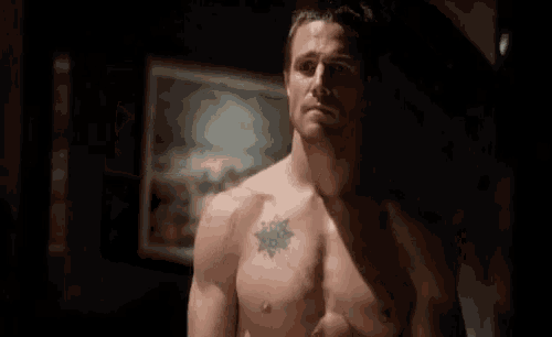a shirtless man with a tattoo on his chest .