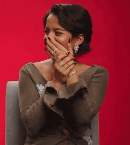 a woman is sitting in a chair and laughing