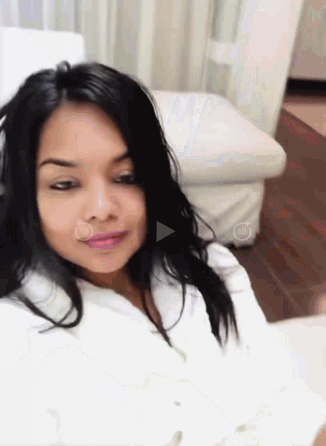 a woman 's face is shown with a play button in the corner