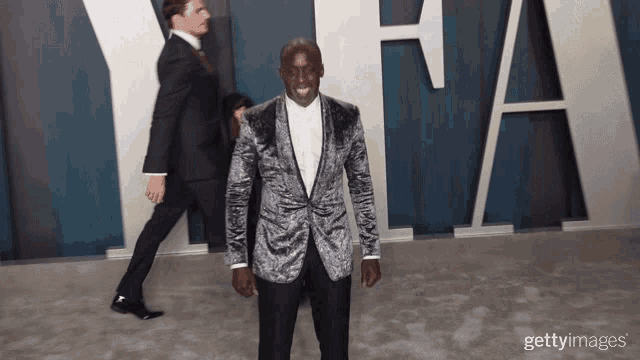 a man in a suit is standing in front of a sign that says fa