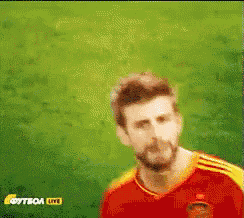 a man with a beard is wearing a red and yellow jersey and says " vamos "