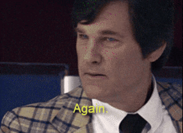 a man wearing a plaid jacket and tie says " again "