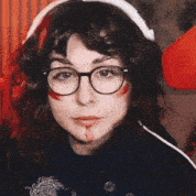 a woman wearing glasses and headphones looks at the camera .