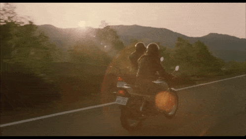 two people riding a motorcycle with a license plate that says 48-20