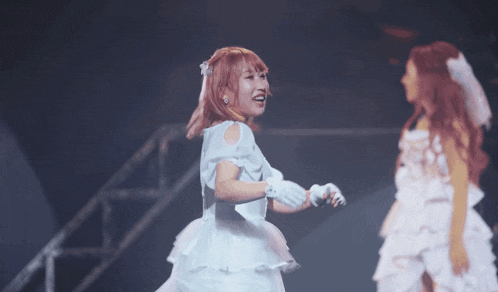 a woman in a white dress is holding a microphone and smiling