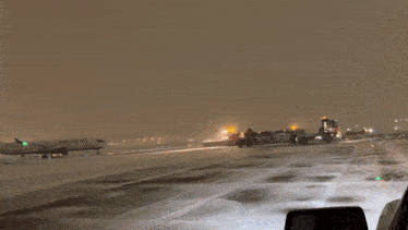 a canadian airlines plane is on a snowy runway at night