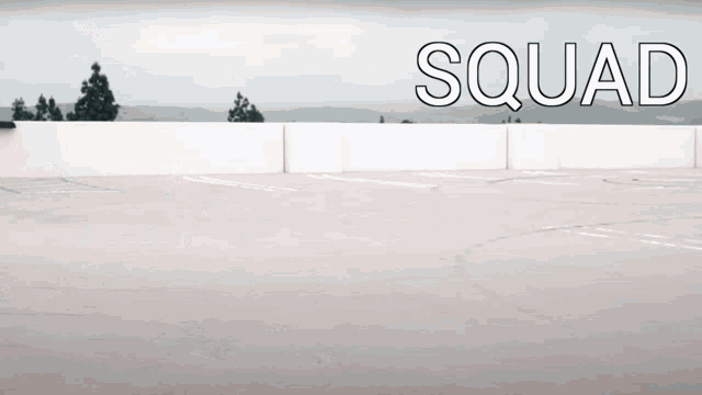 a person is riding a bike in a parking lot with the word squad written above them