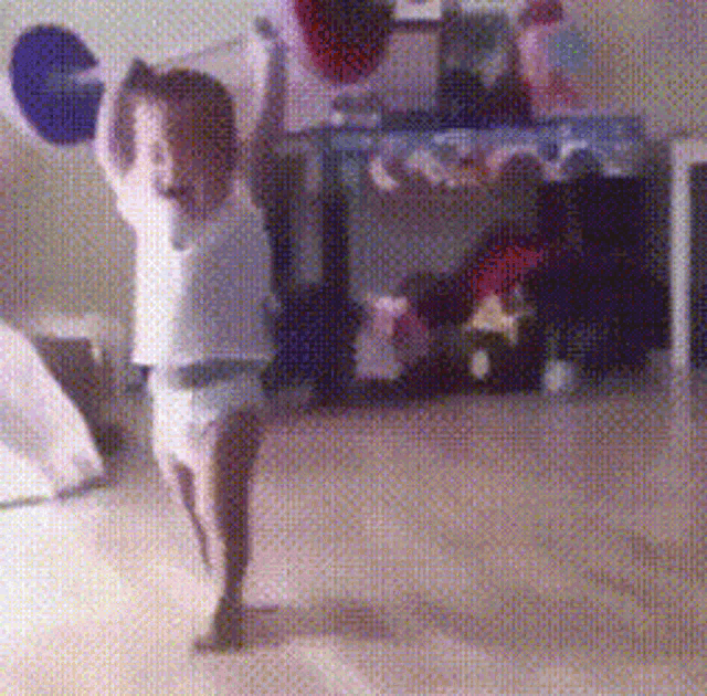 a child in a diaper is holding a barbell in his hands