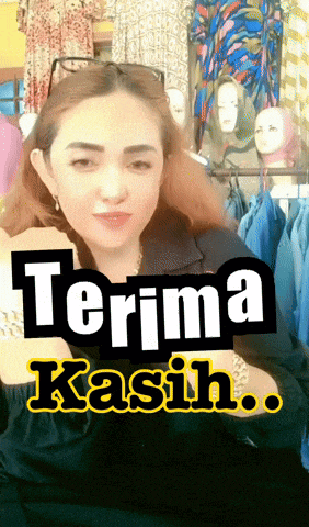 a woman is standing in front of a sign that says " terima kasih "