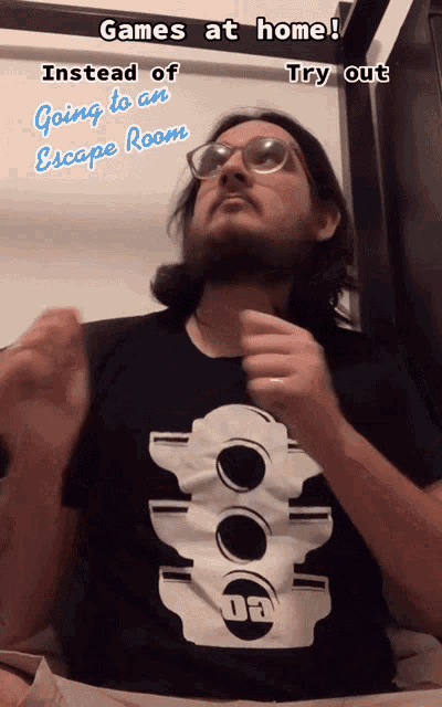 a man wearing glasses and a black shirt that says da on it