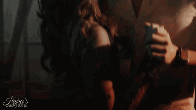 a woman is being held by a man in a dark room with the words " kaira 's creations " on the bottom right