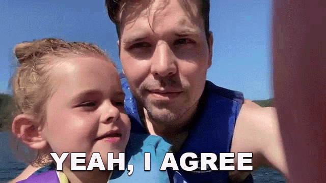 a man holding a little girl with the words " yeah i agree " above them