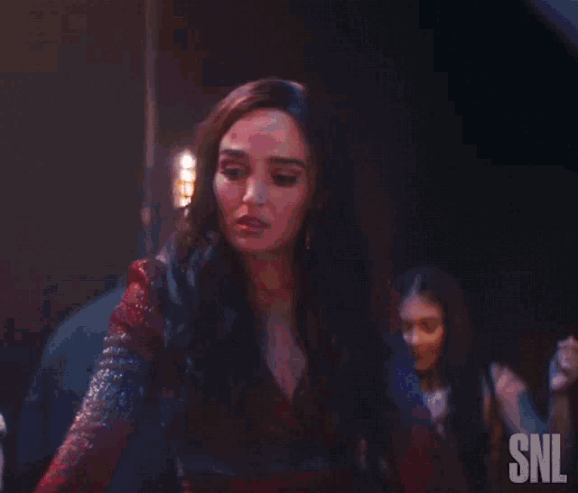 a woman in a red dress with snl written on the bottom right