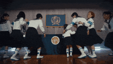 a group of people are dancing in front of a sign that says ' tokyo '