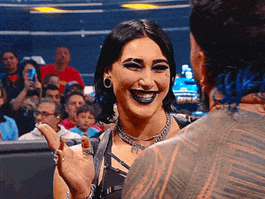 a woman with makeup on her face is smiling at a man with a tattoo on his back