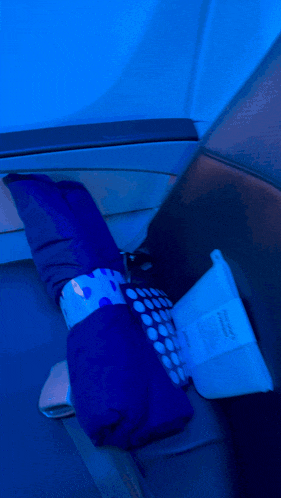 a blue pillow with white polka dots on it sits on a blue chair