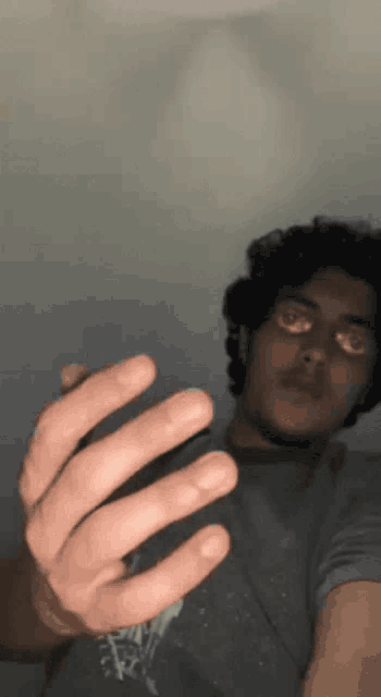 a man is taking a selfie with his hand in the air
