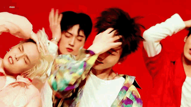a group of young men are dancing in a red room .